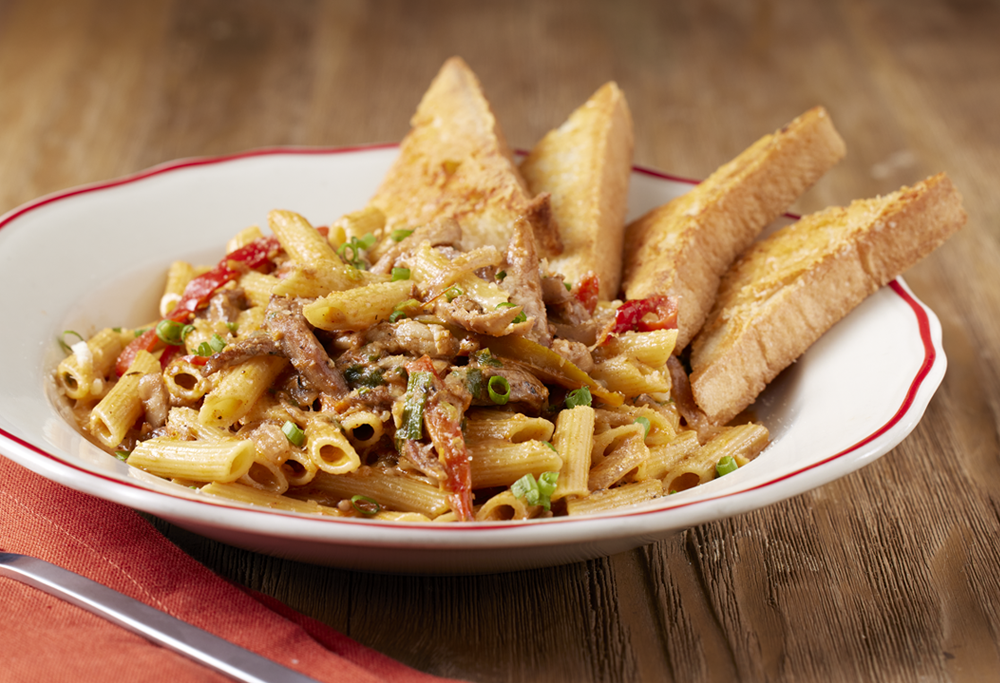 Plate of Cajun Pasta on a wood background.