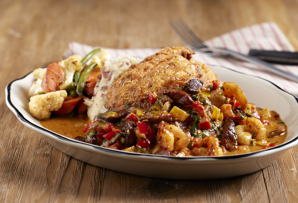 A plate of Mardi Gras Chicken on a wood background